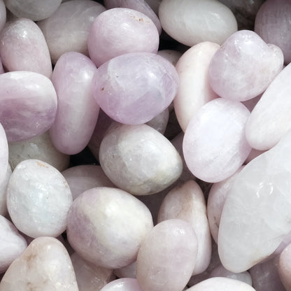 Smooth kunzite tumbled stones promoting emotional healing and creativity with soft pastel hues.