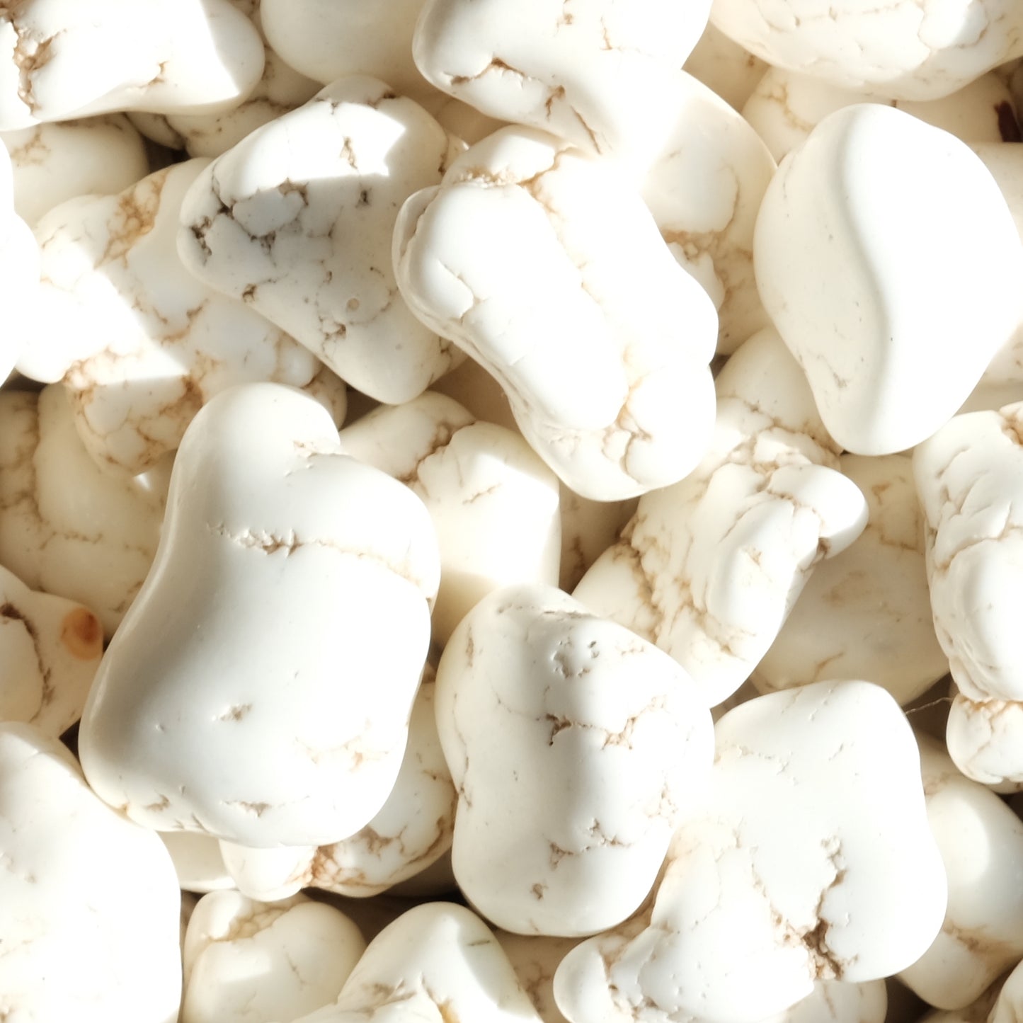 Smooth white magnesite nuggets with natural veining, ideal for enhancing mental clarity and promoting a positive mindset.