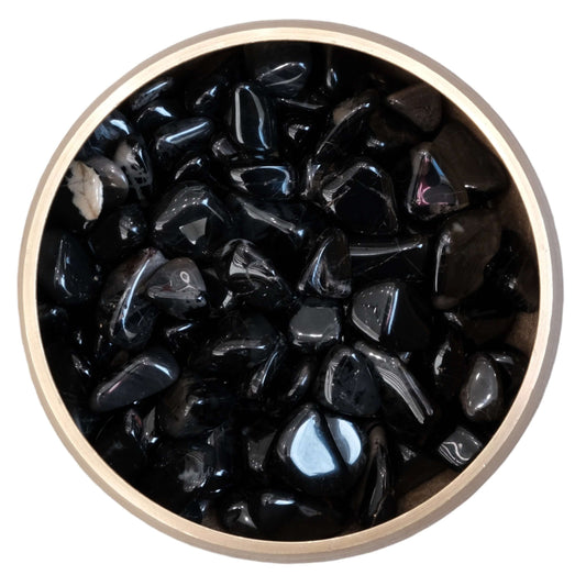 Bowl of polished black onyx tumble stones for vigor and self-confidence.