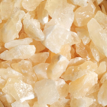 Honey Calcite rough stones in natural light showcasing their golden hue and textured surface.