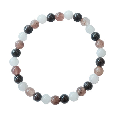 A beaded stretch bracelet made of alternating polished round beads in black, translucent white, and dusty rose pink, displayed on a clean white background.