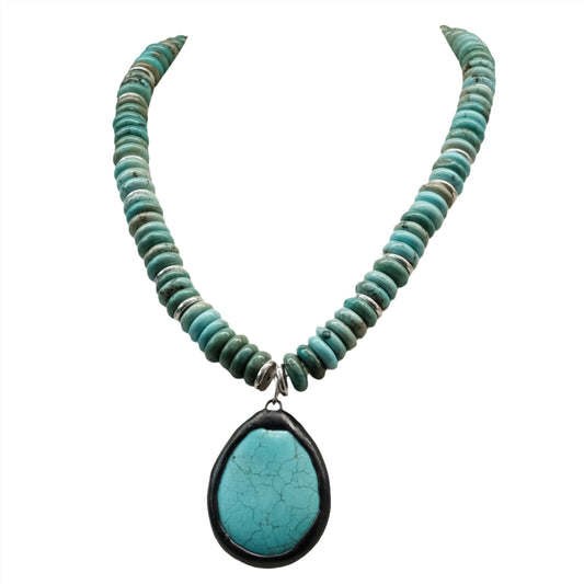 Turquoise necklace with turquoise drop pendant, featuring a string of round turquoise beads.