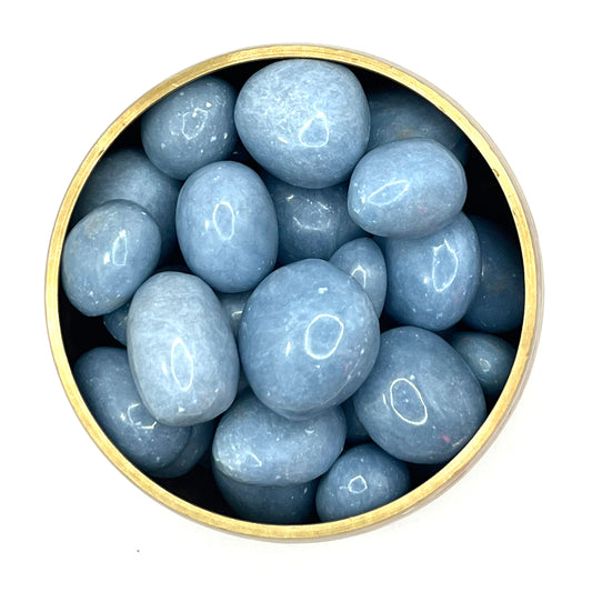Angelite tumbled stones in a round container, displaying calming blue hues and promoting peace, tranquility, and spiritual awareness.